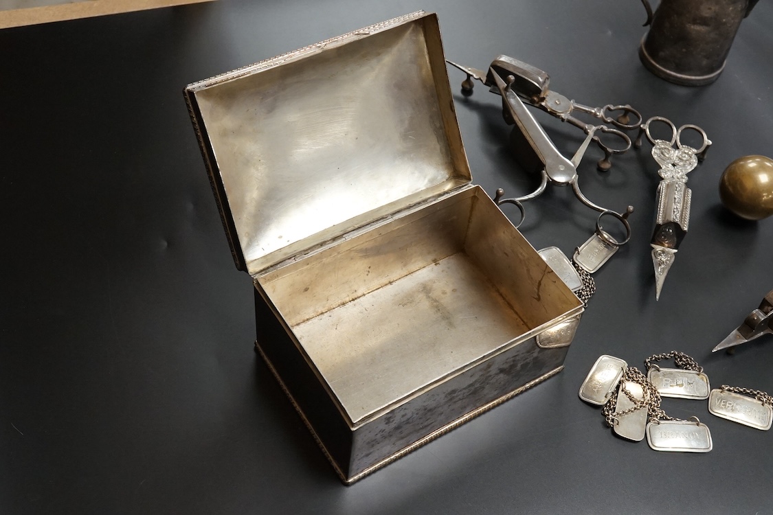 Four assorted pairs of 19th century plated candle snuffers, a large plated box, plated cream jug, ball and seven plated wine labels. Box 10cm high x 16.5cm wide.